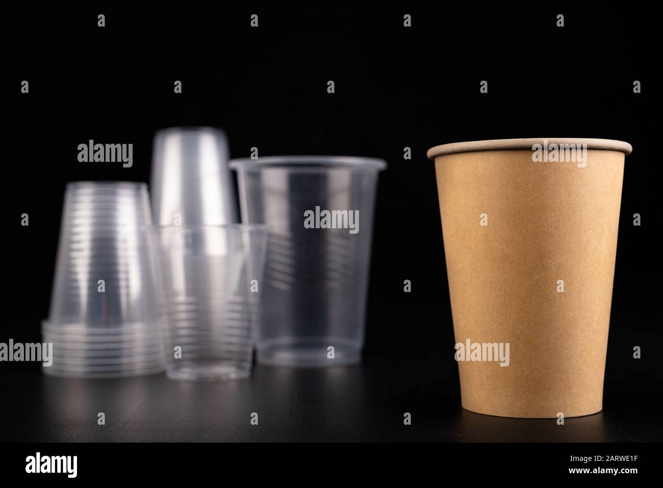 Plastic versus cardboard cups. Disposable tableware set on a table ...