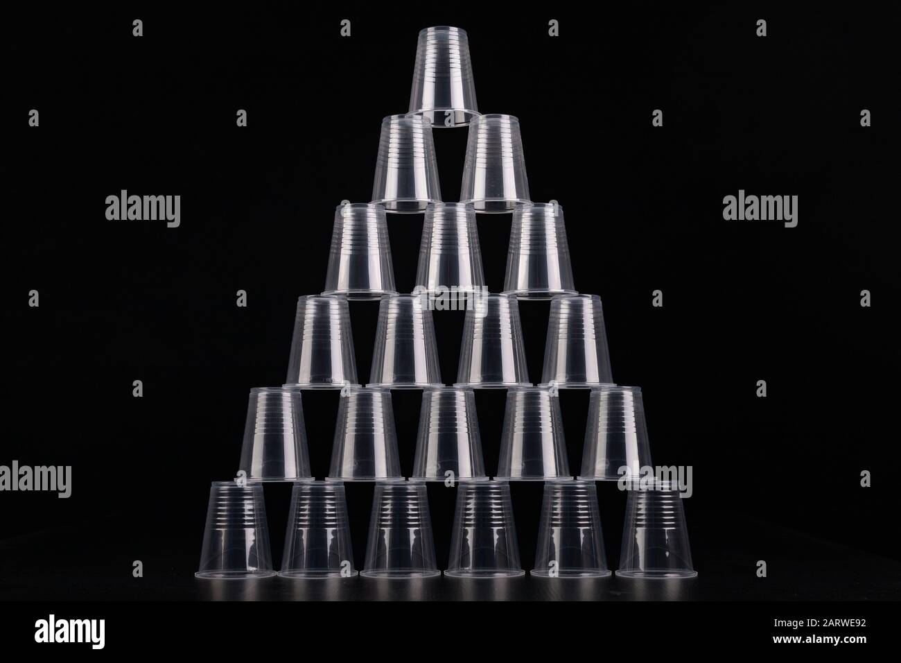 Plastic versus cardboard cups. Disposable tableware set on a table. Dark background. Stock Photo