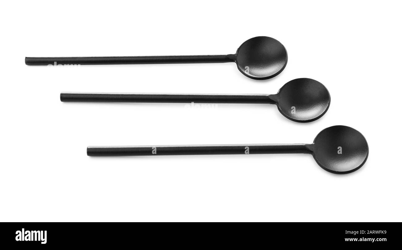 Black spoons on white background Stock Photo - Alamy