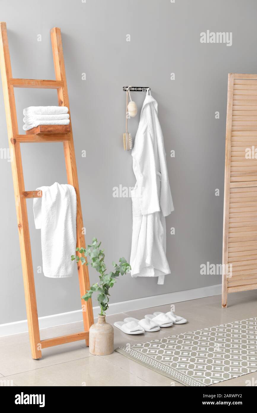 Clean bathrobe hanging on wall in room Stock Photo Alamy