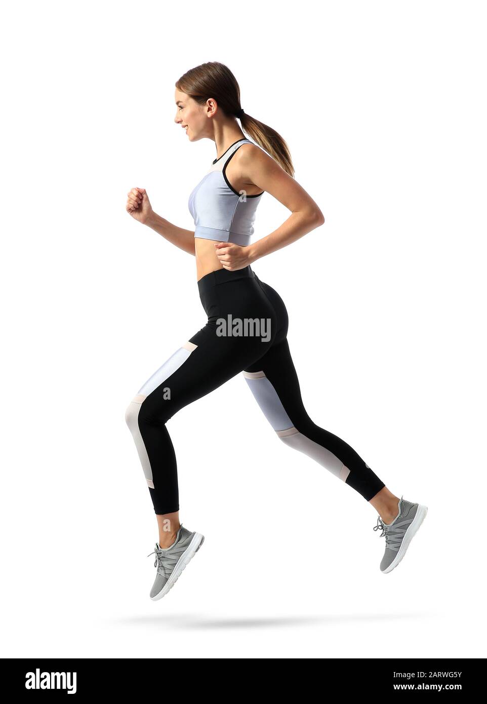 Sporty young woman running against white background Stock Photo - Alamy
