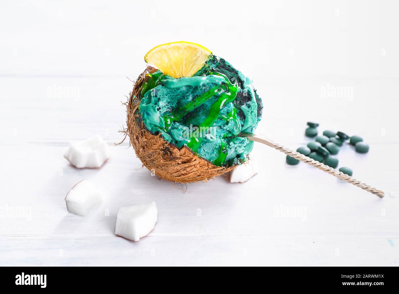 Tasty spirulina icecream in coconut shell on white table Stock Photo