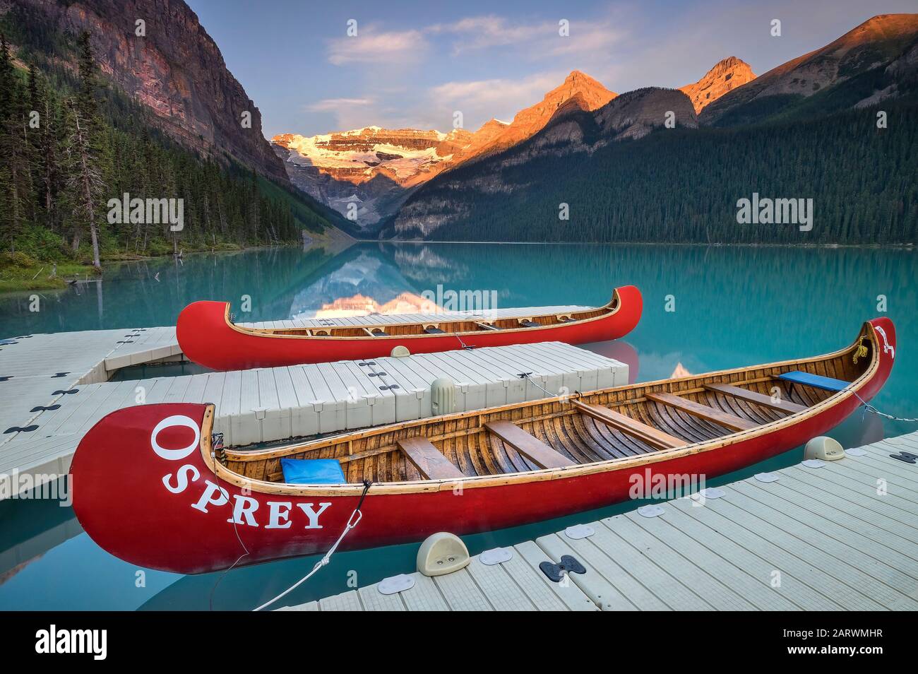 Canoes at Sunrise on Lake Louise backed by The Victoria Glacier, Lake Louise, Banff National Park, Alberta, Canada Stock Photo