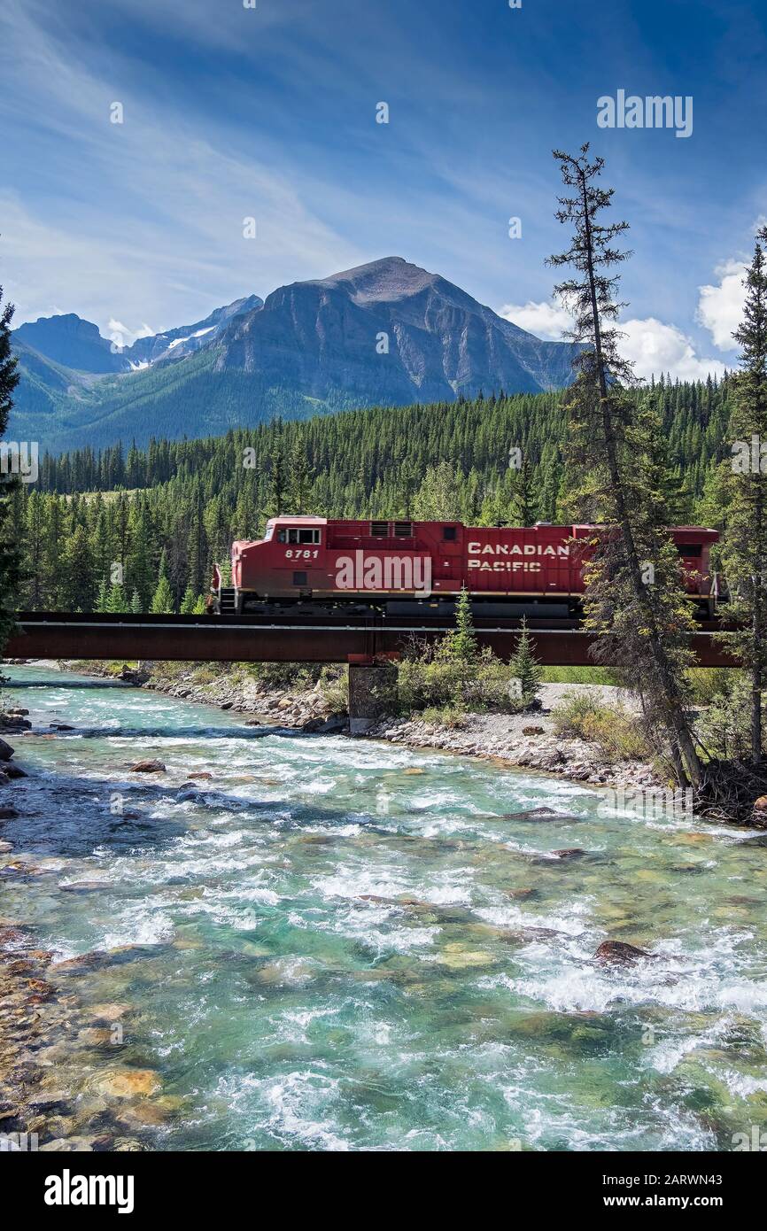 Canadian Pacific Railroad Train crossing the Bow River backed by Fairview Mountain,The Rockies, Alberta, Canada Stock Photo