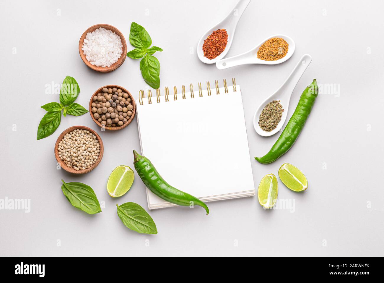 Empty notebook with different spices on white background Stock Photo