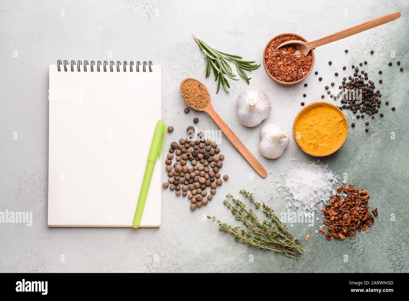 Empty notebook with different spices on light background Stock Photo