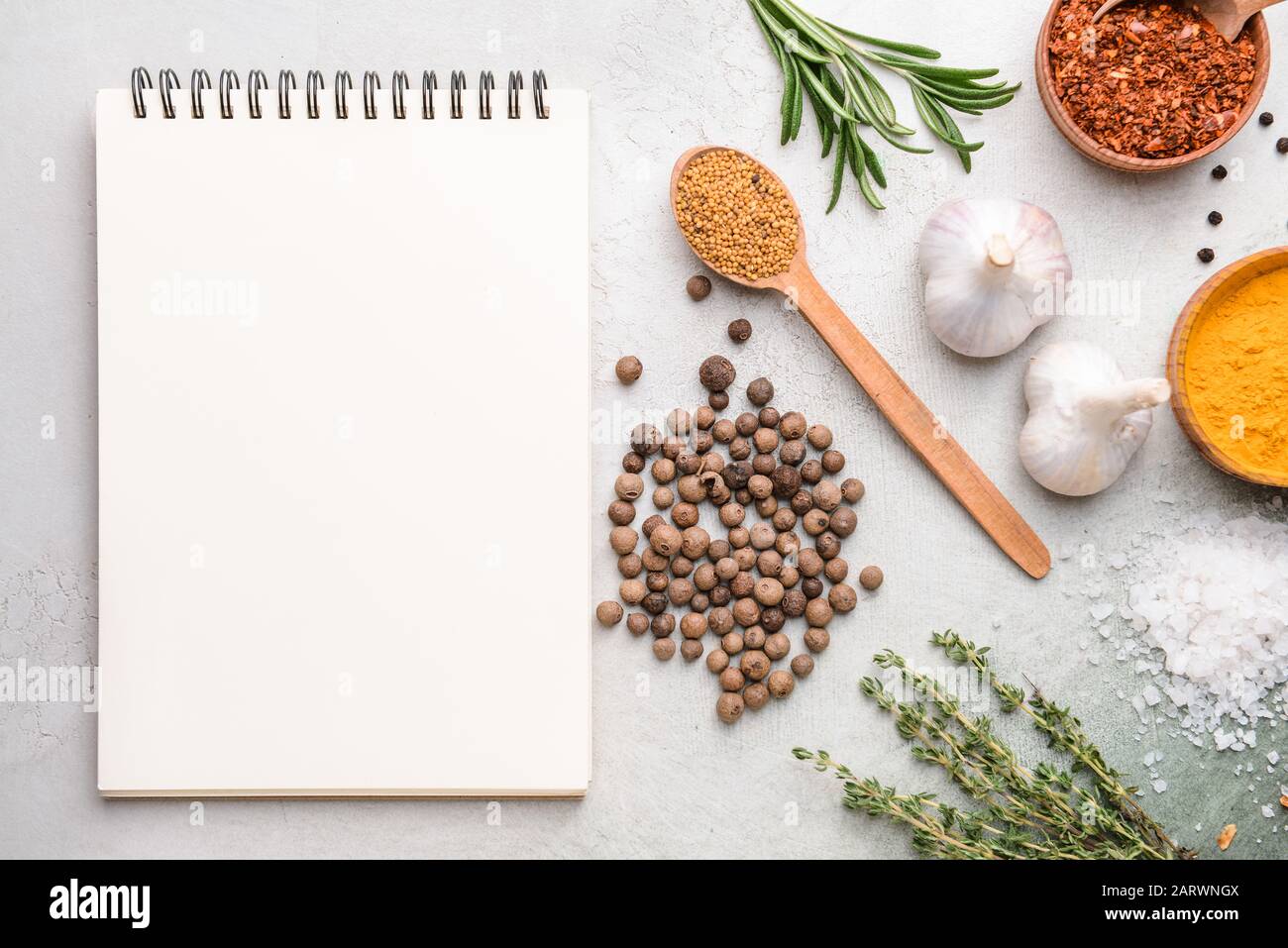 Empty notebook with different spices on light background Stock Photo