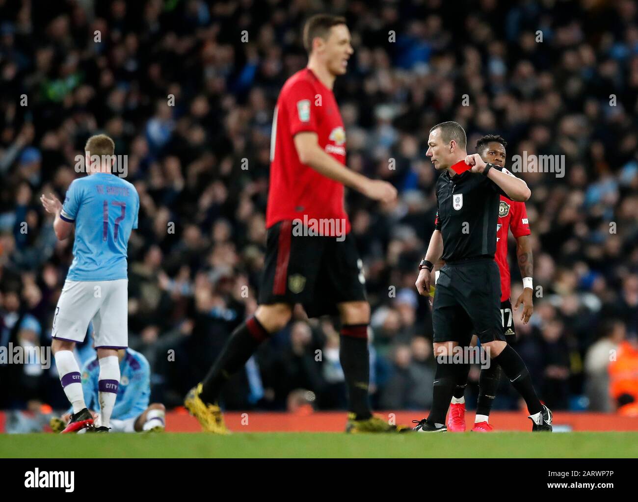 Referee Kevin Friend shows a red card to Manchester United's Nemanja Matic (centre) after receiving a yellow card for a foul during the Carabao Cup Semi Final, second leg match at