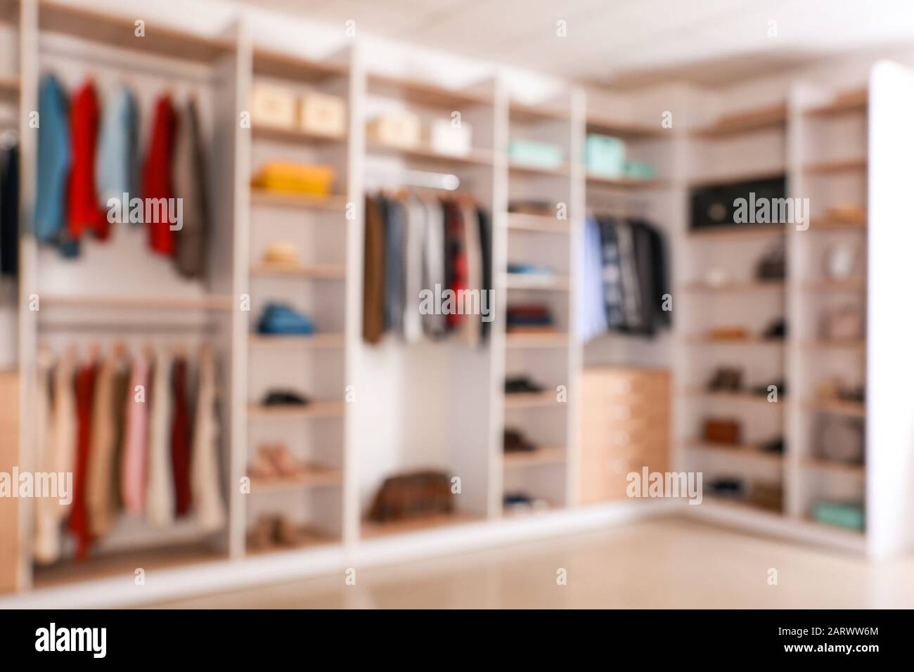 Big wardrobe with clothes in dressing room blurred view Stock