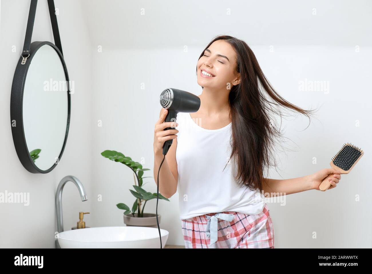 Morning of beautiful young woman drying hair in bathroom Stock Photo ...
