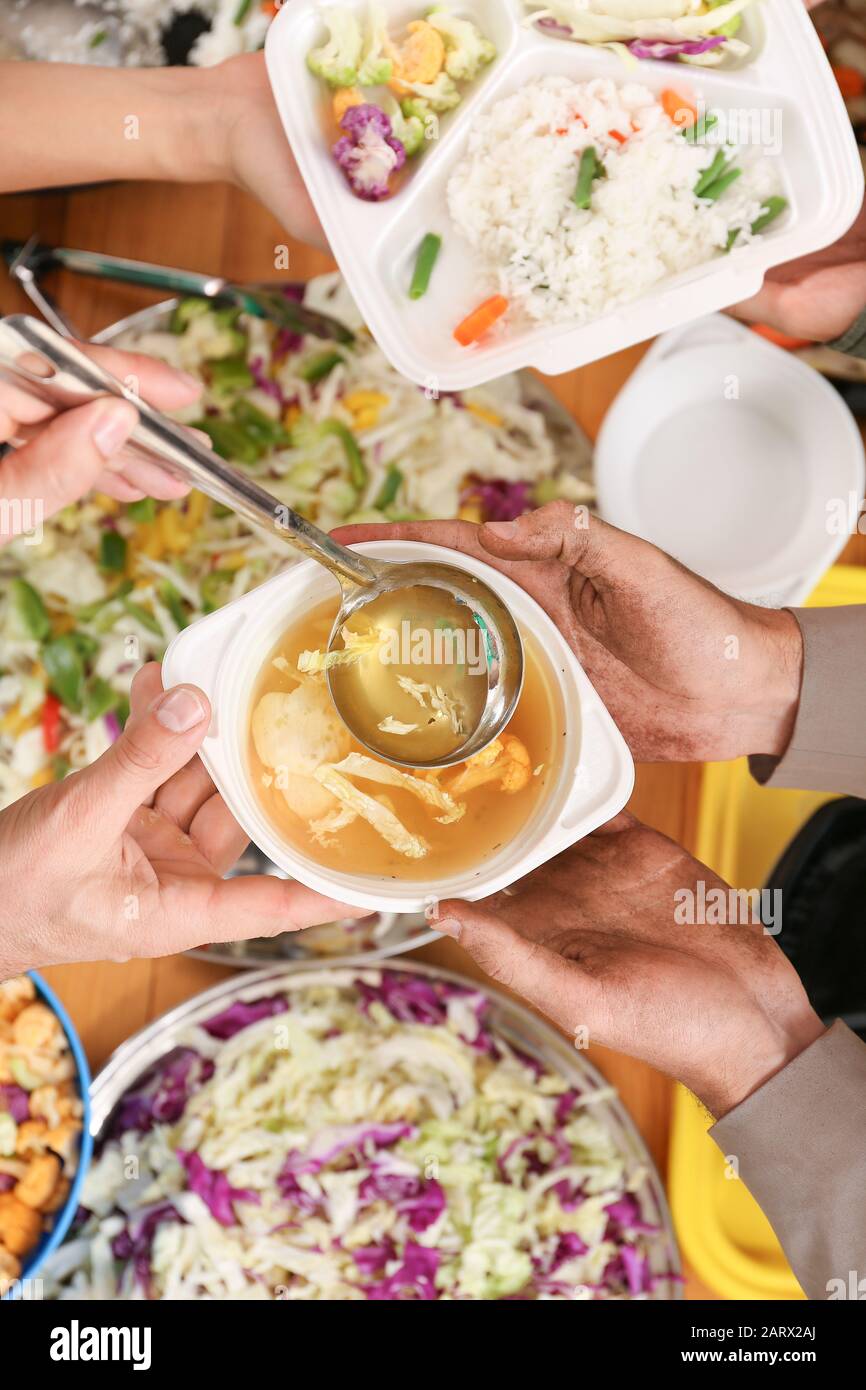 Volunteers giving food to homeless people, top view Stock Photo - Alamy