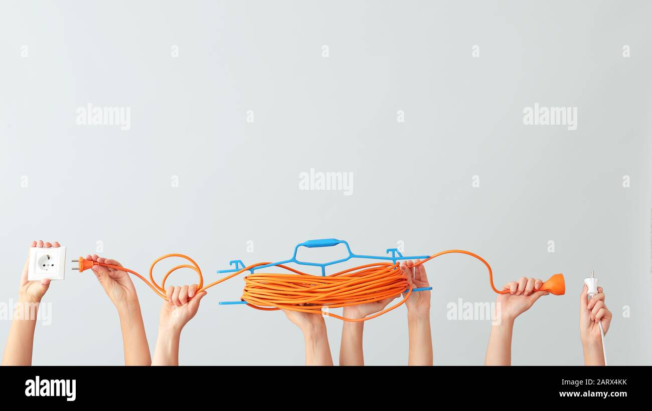 Female hands with electrician's tools on light background Stock Photo