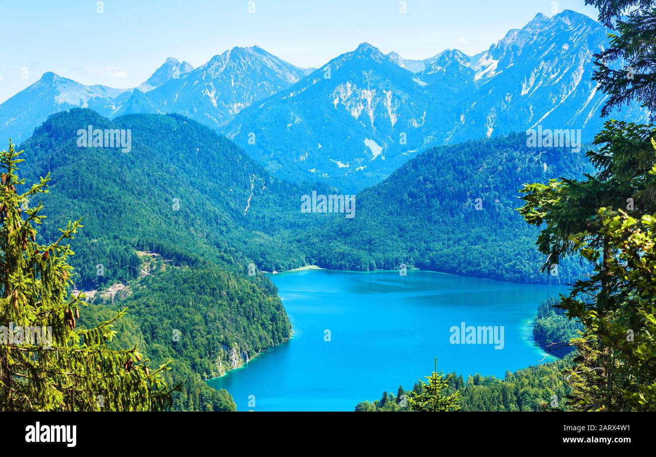 Landscape of Alpine mountains, Germany. Panoramic scenic view of nature from above. Perfect landscape with Alpsee lake in summer. Beautiful scenery of Stock Photo