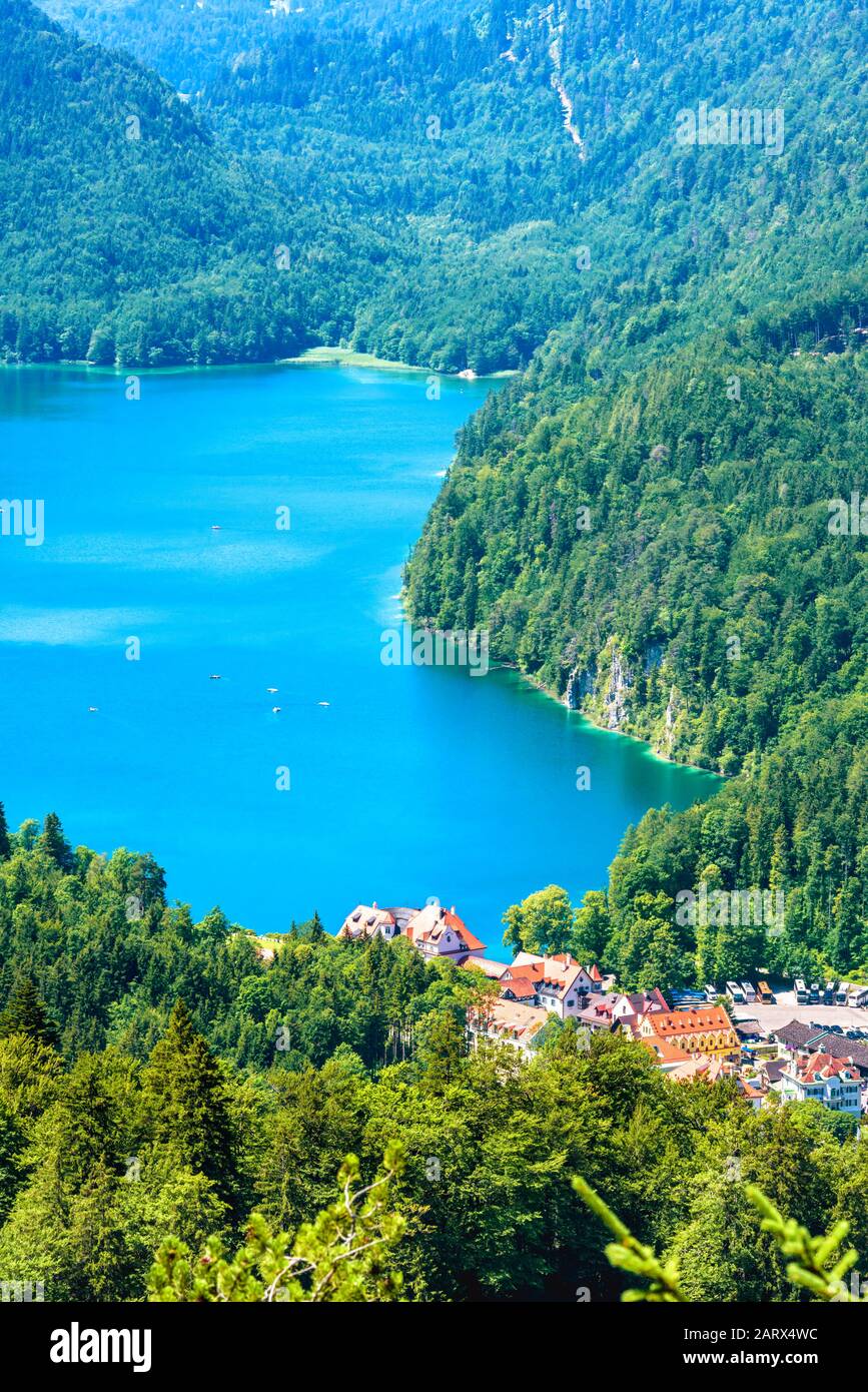 Landscape of Alpine mountains, Germany. Scenery of Bavarian Alps in summer. Nice landscape with Alpsee lake and Hohenschwangau village in green forest Stock Photo