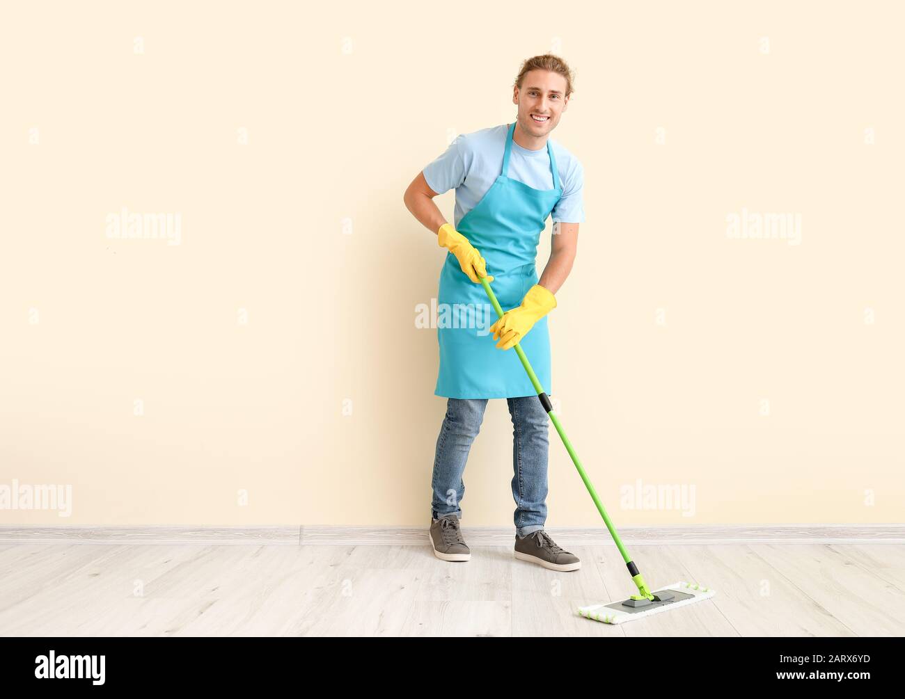 Male janitor mopping floor in room Stock Photo