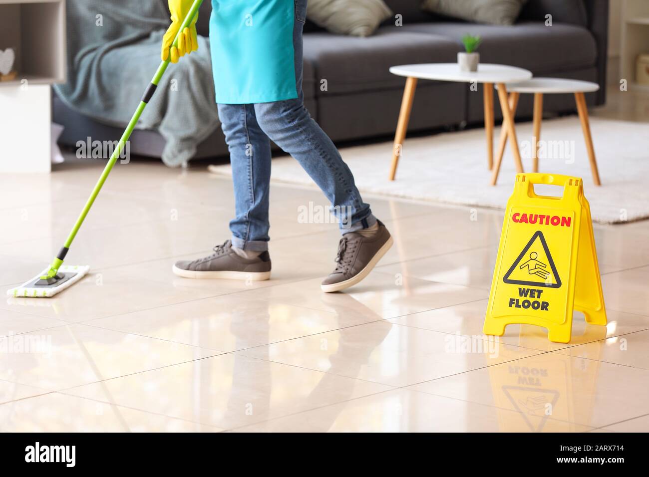 Male janitor mopping floor in flat Stock Photo