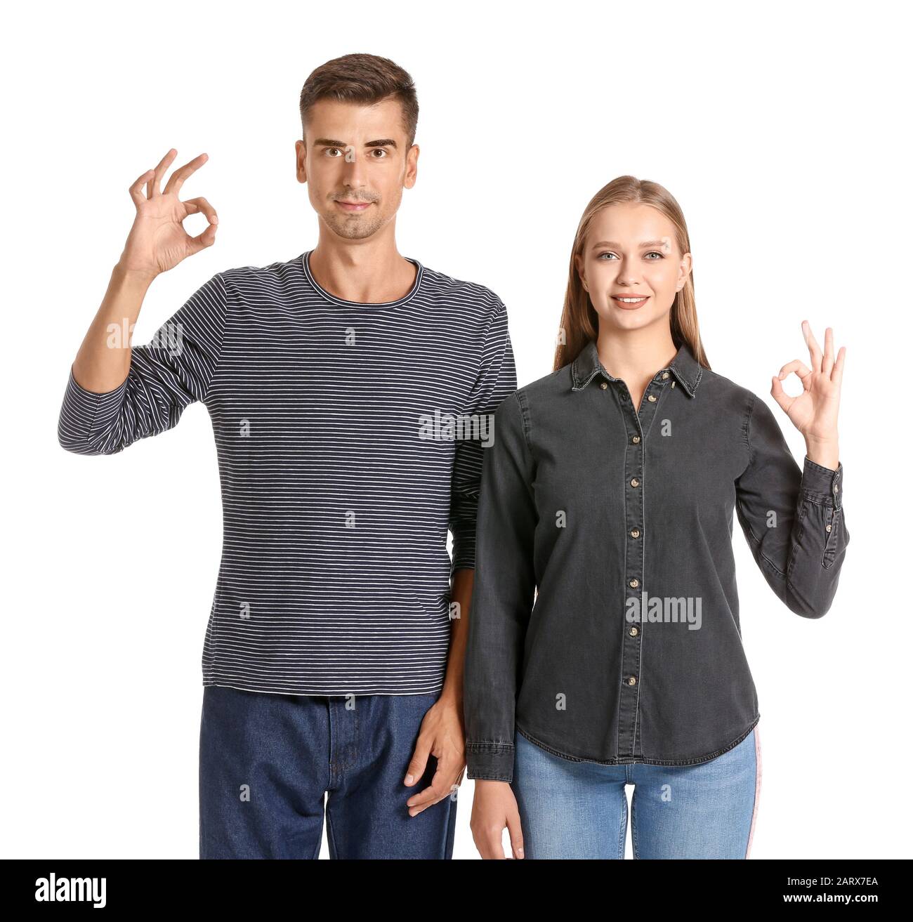 Young deaf mute couple using sign language on white background Stock