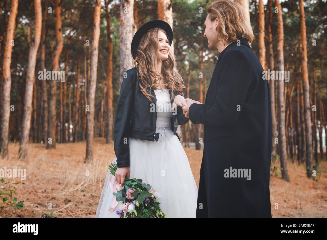 Happy man putting wedding ring on his fiancee's finger outdoors Stock