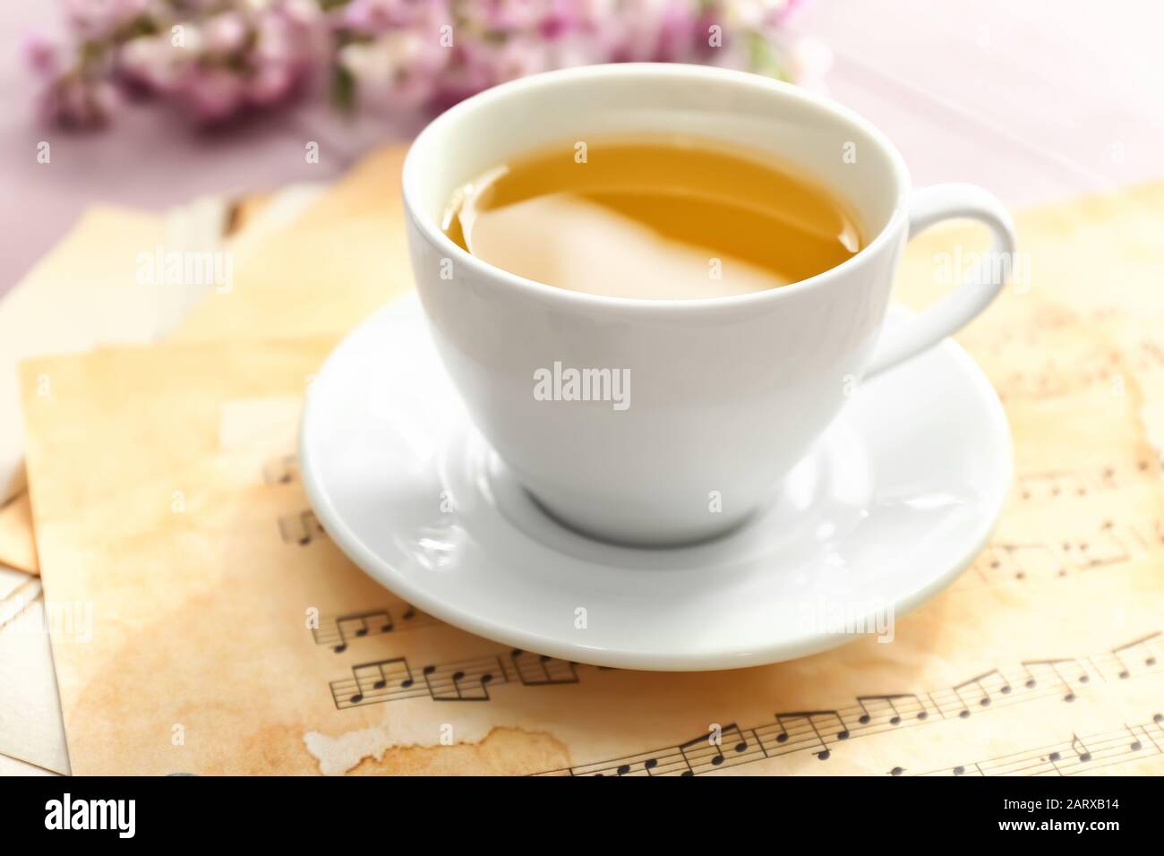 Cup of hot tea with music sheets on table Stock Photo