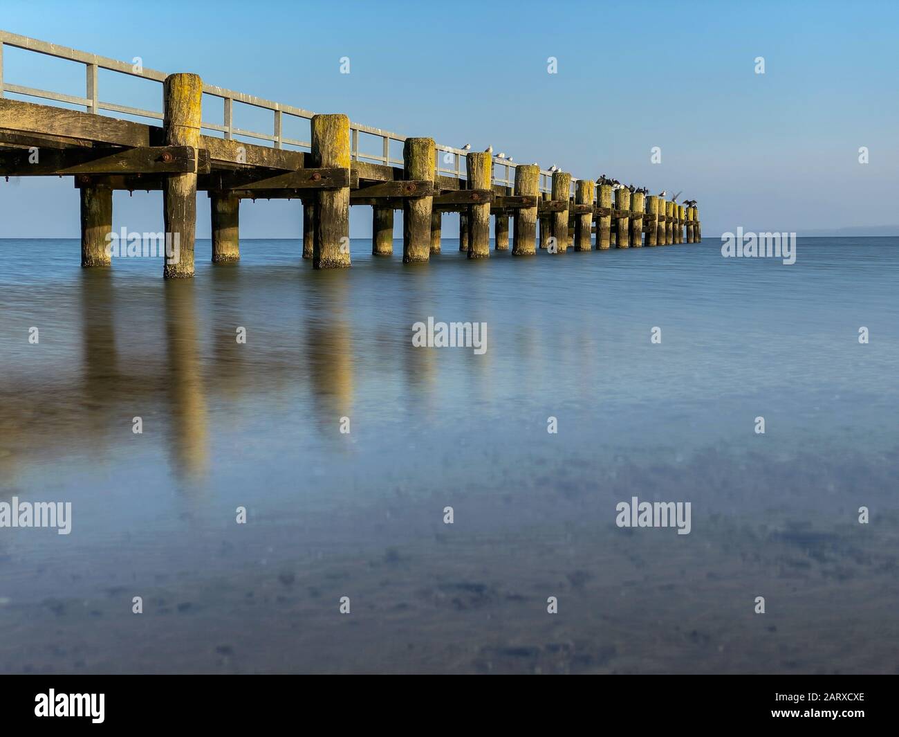 Old wooden pier at the coast Stock Photo
