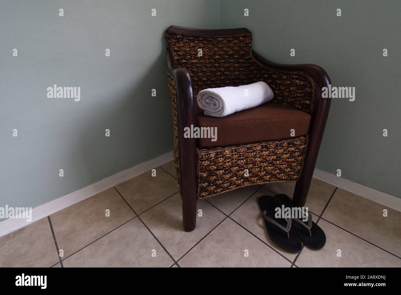 Rattan Armchair With Clean Towel And Shower Slippers Stock Photo