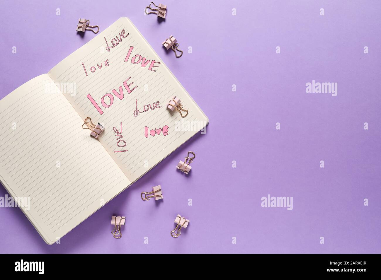 Open notebook with written words LOVE on color background Stock Photo