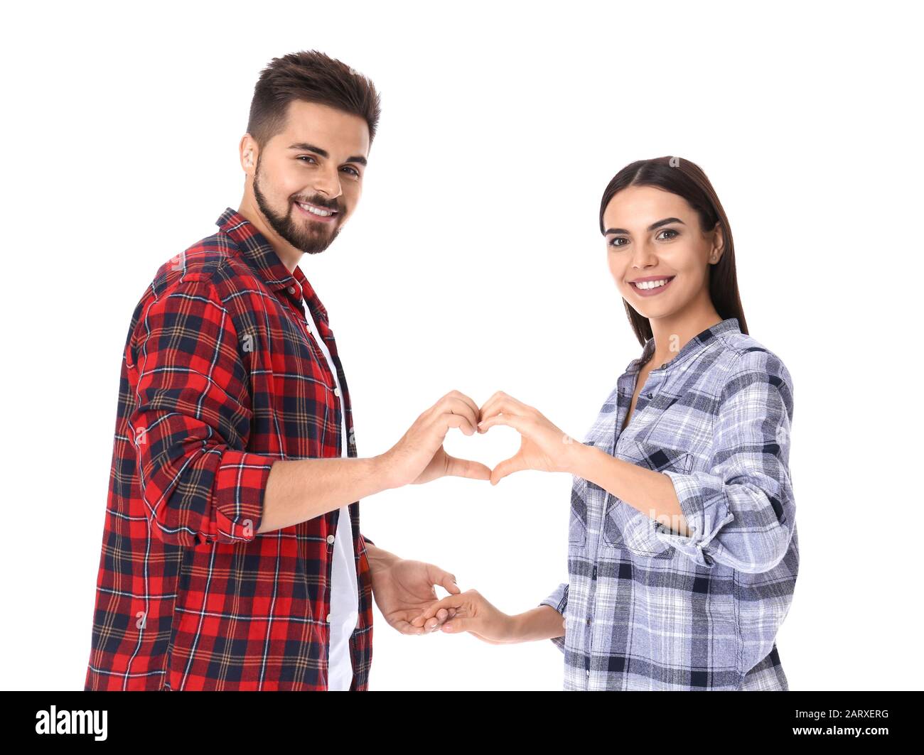 Portrait of beautiful young couple holding hands in shape of heart on ...