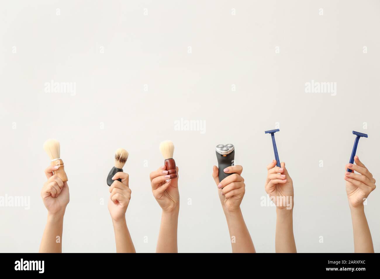 Hands with different tools for shaving on white background Stock Photo