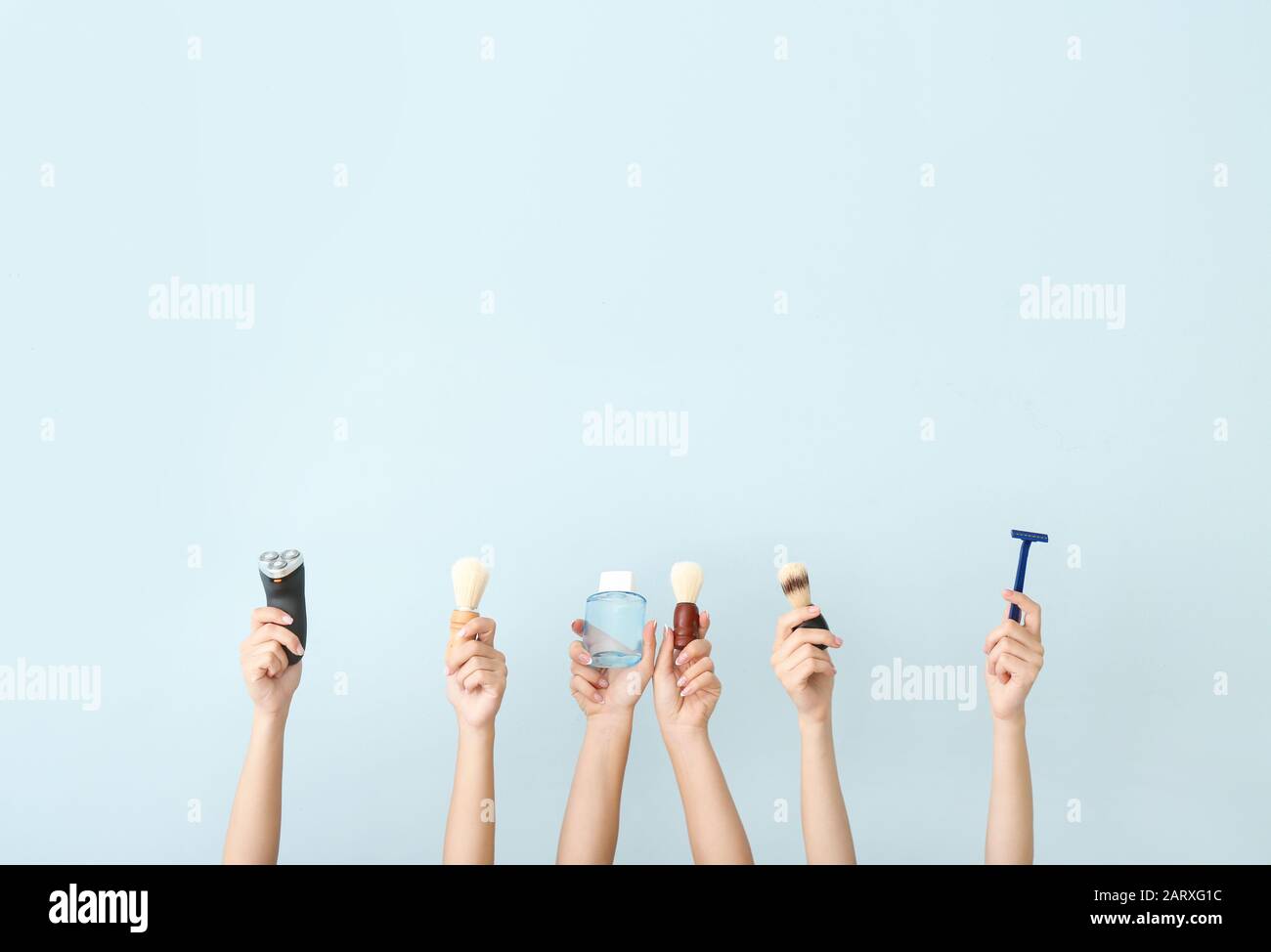 Hands with different tools for shaving on color background Stock Photo
