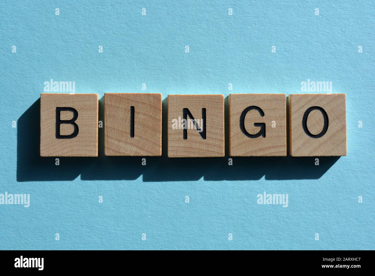 Bingo, word in 3d wooden alphabet letters on blue background with copy space Stock Photo