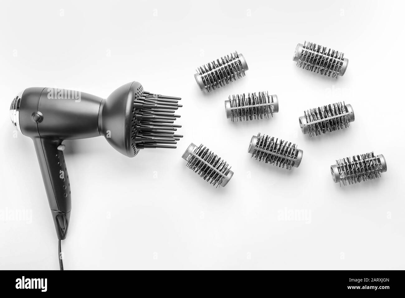 Blow dryer and hair curlers on white background Stock Photo Alamy