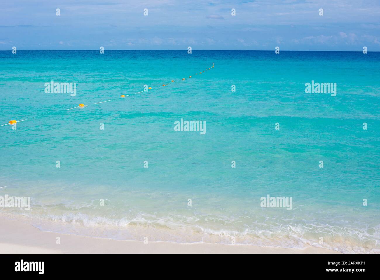 White and red round marker buoys rope floating in a sea, marking an end