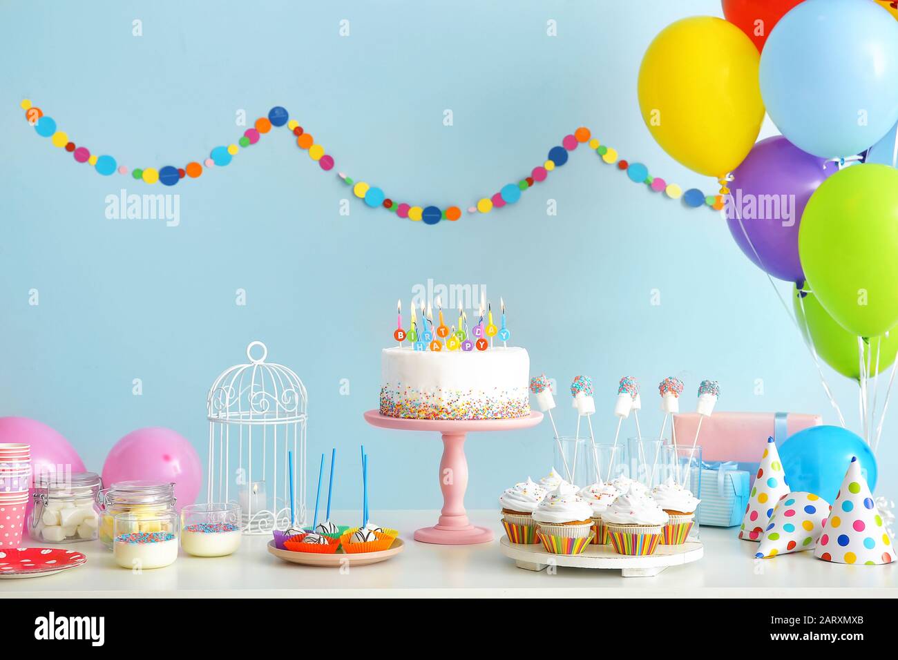 Tasty candy bar for Birthday party on table against color background Stock Photo