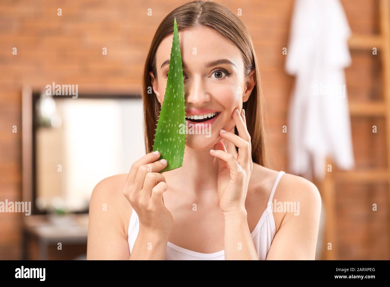 Beautiful young woman with aloe vera in bathroom Stock Photo Alamy