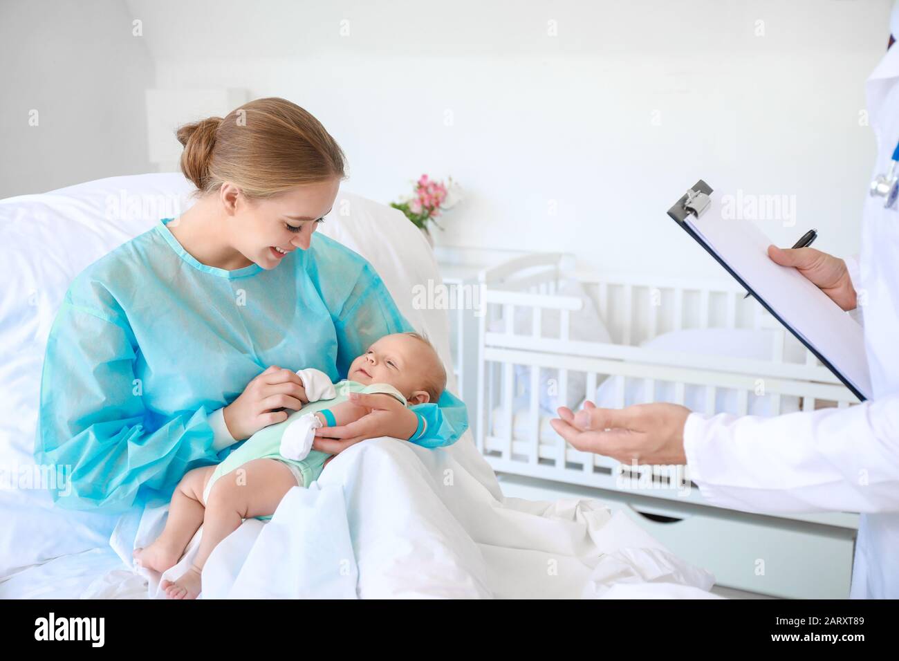 Young woman with newborn baby and gynecologist in maternity hospital ...