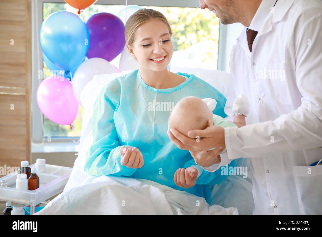 Young woman with newborn baby and gynecologist in maternity hospital ...