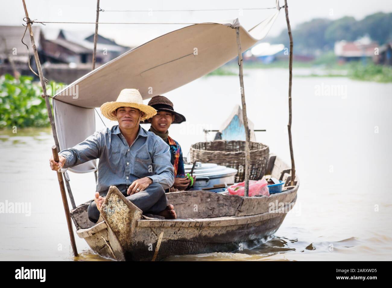 Puok, Siem Reap Province, Cambodia - 4 April 2013: Local Cambodian couple rowing along Tonle Sap lake at floating village Stock Photo