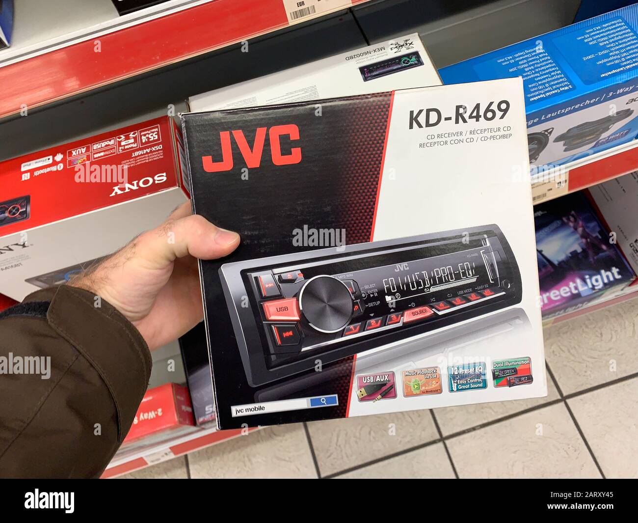 Dortmund, Germany - Mar 25, 2019: Man customer hand holding package of new  auto radio manufactured by