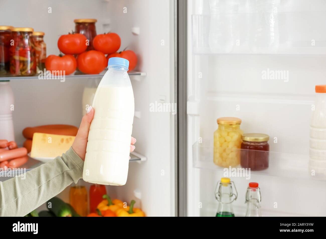 Woman taking food out of fridge Stock Photo Alamy