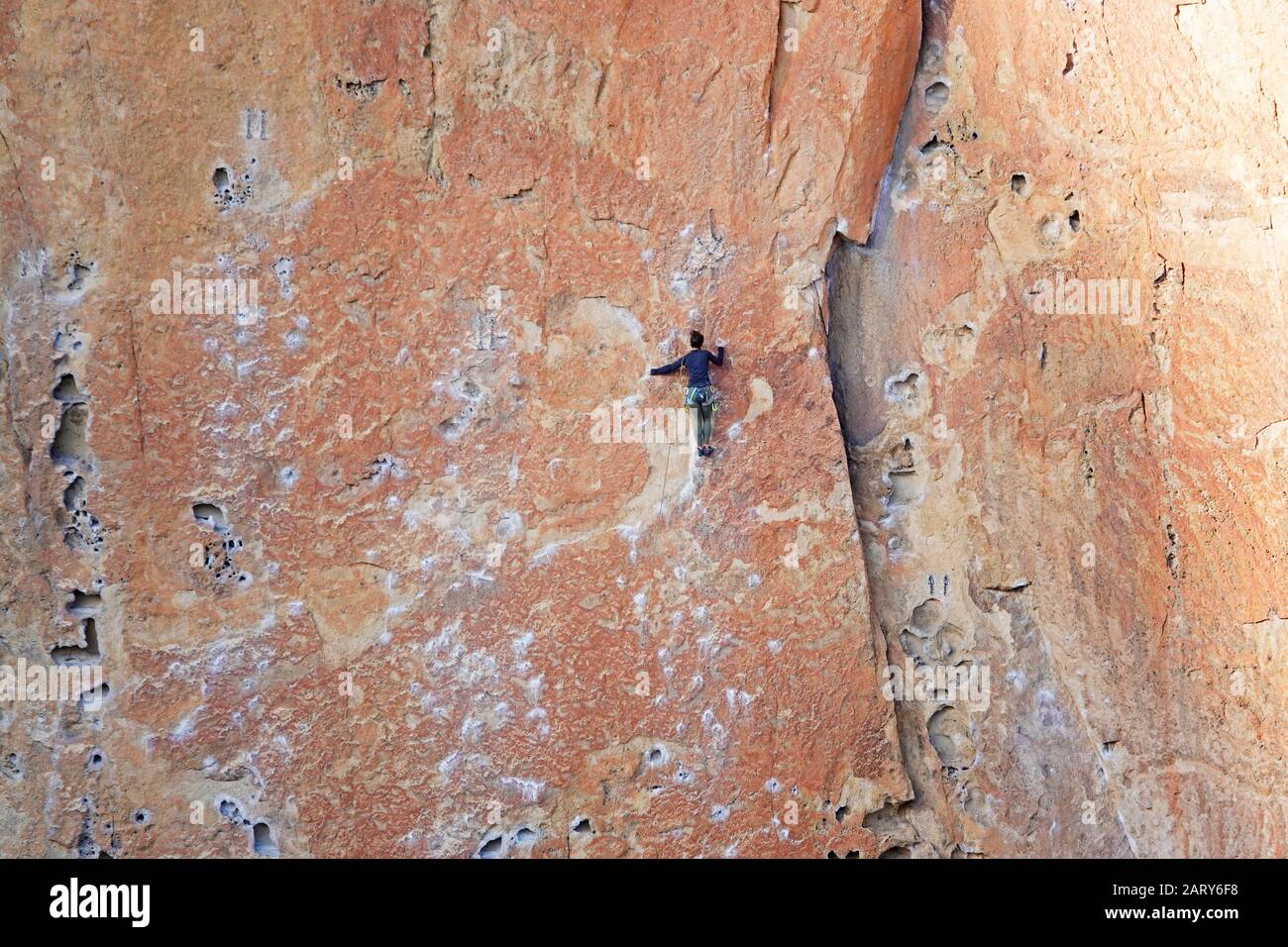 A rock climber negotiates a wall at Smith Rock State Park in Oregon ner the village of Terrebonne. Made of tuff, or hardened volcanic ash, the Rock ha Stock Photo