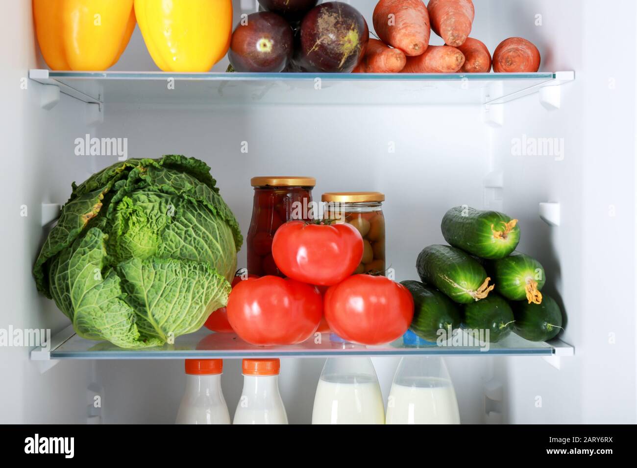 Different products on shelves in fridge Stock Photo