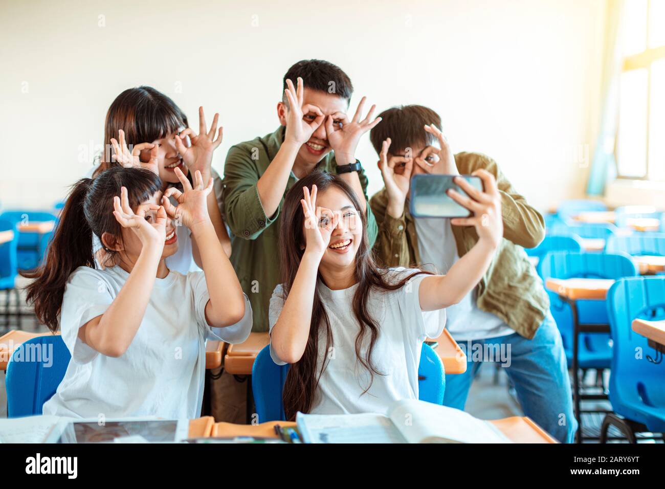 happy young group of teenagers making fun selfie in classroom Stock Photo