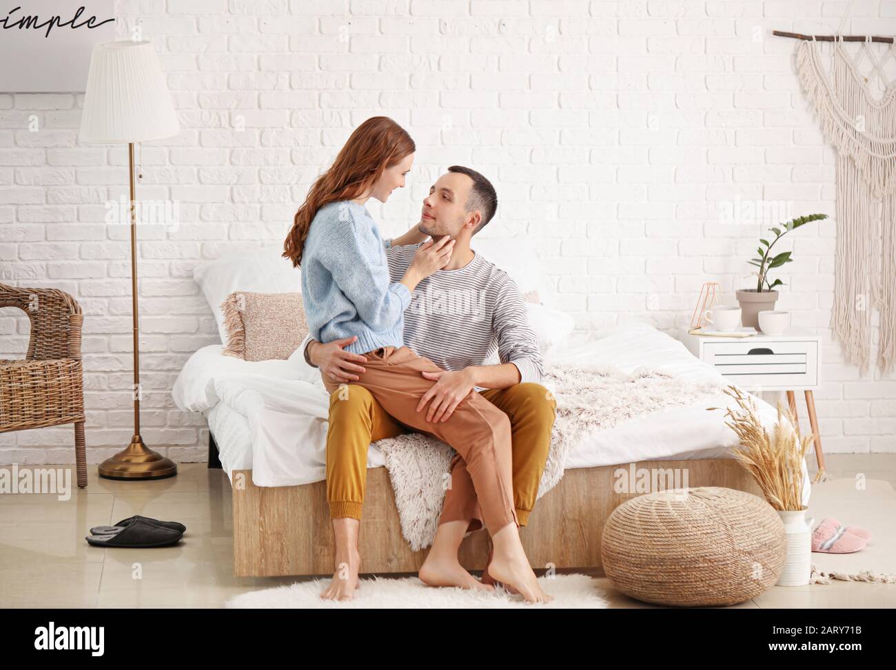 Beautiful young sitting on bed at home Stock Photo Alamy