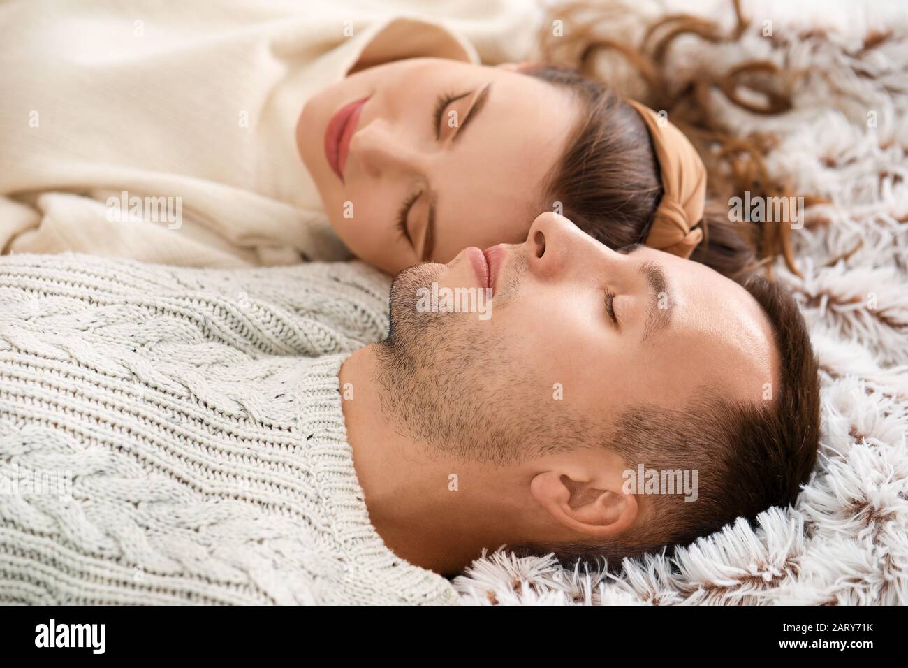 Beautiful young couple sleeping on bed at home Stock Photo
