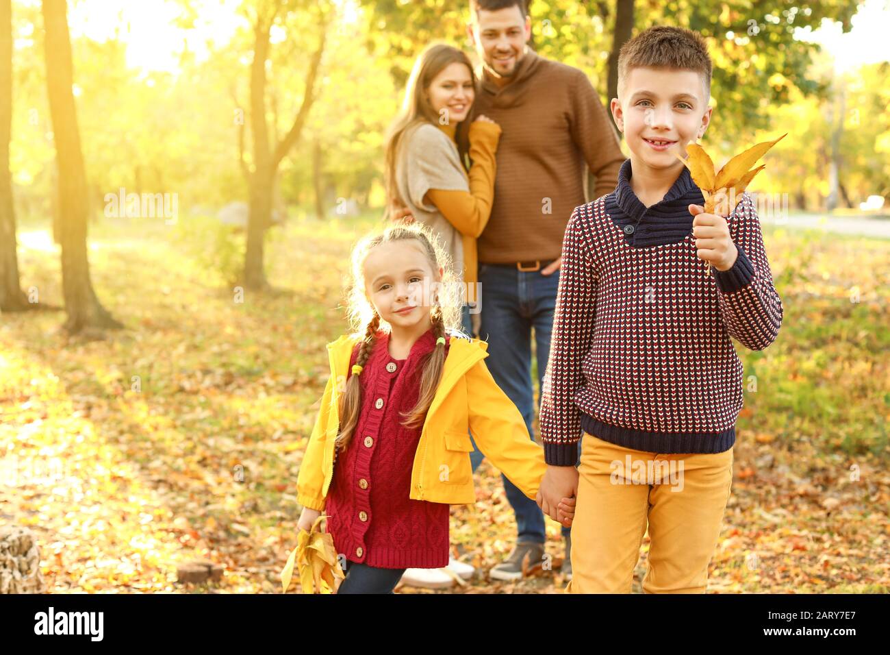 Happy children with parents resting in autumn park Stock Photo