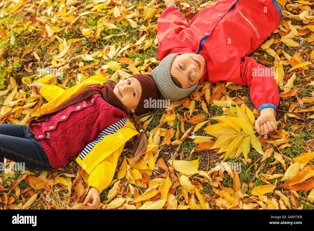 Happy children lying in autumn park Stock Photo