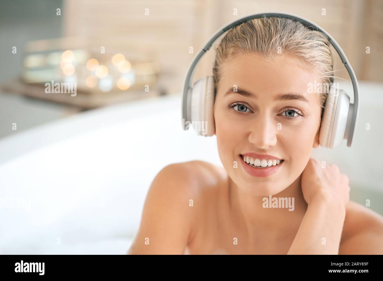 Beautiful young woman listening to music in bathroom Stock Photo Alamy
