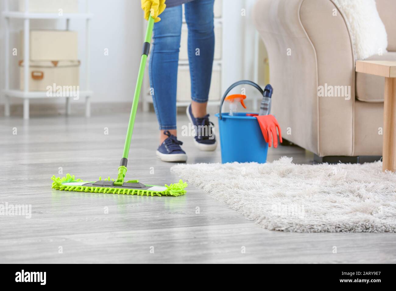 Female janitor mopping floor in room Stock Photo