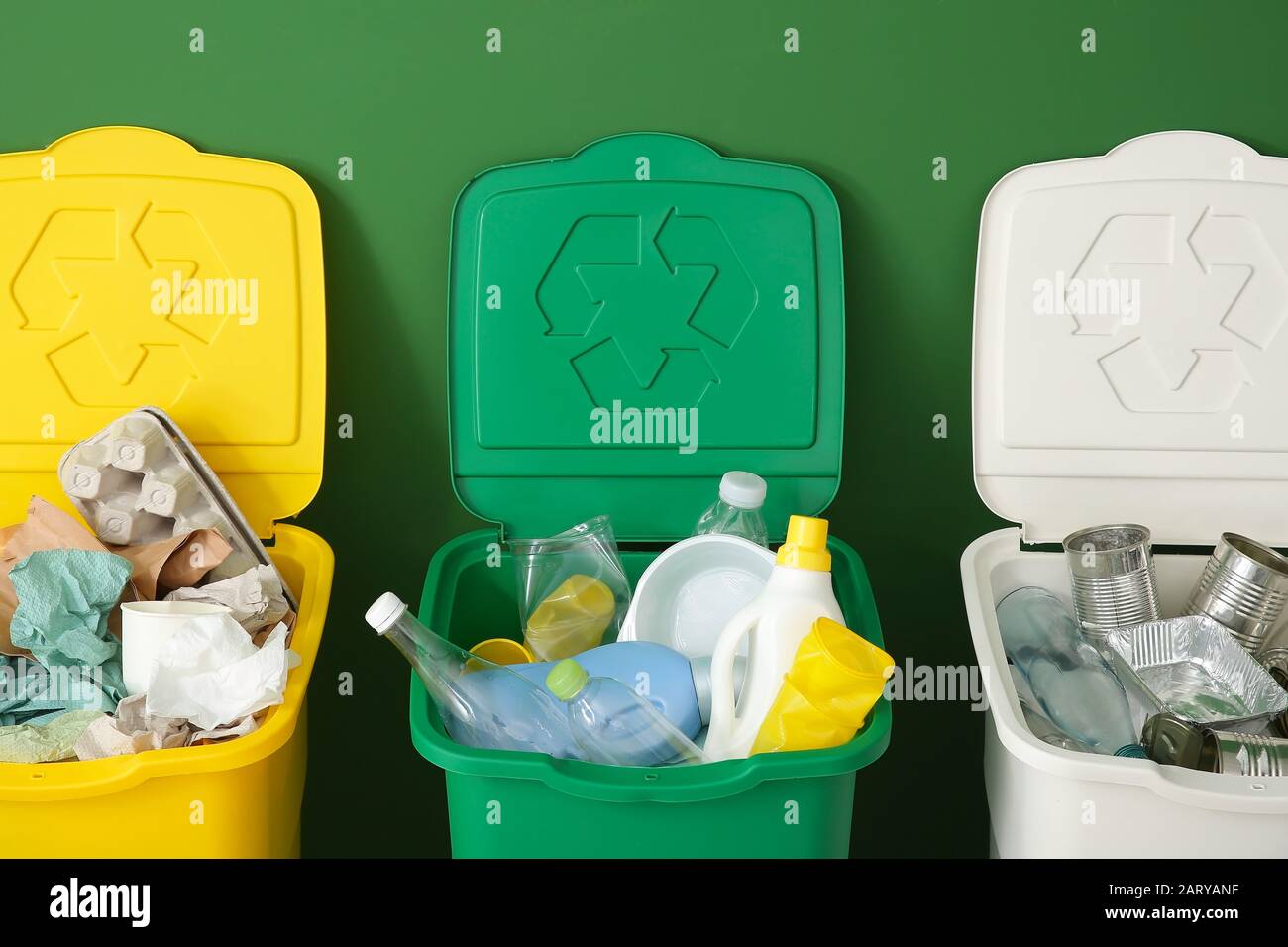 Containers with different types of garbage near color wall. Recycling