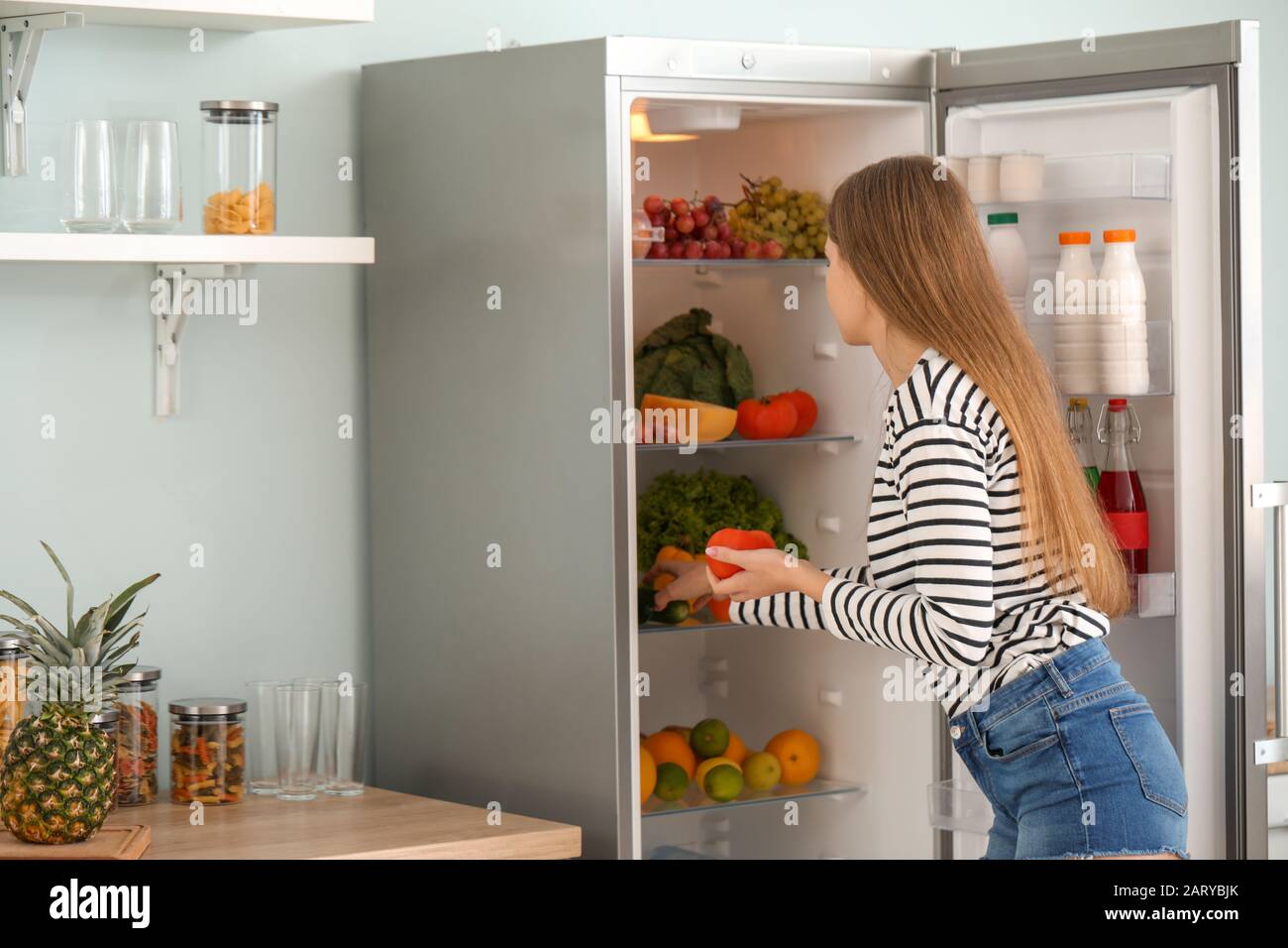 Woman taking food out of fridge at home Stock Photo Alamy